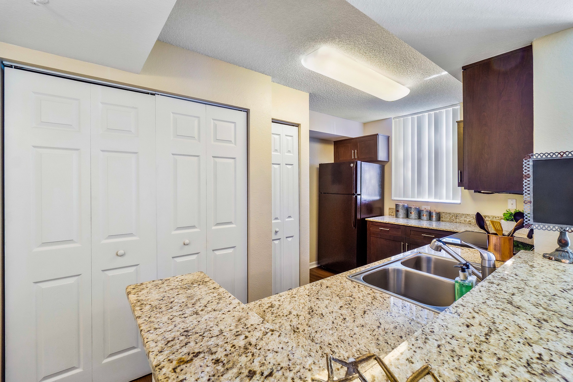 A kitchen with granite countertops and white cabinets.